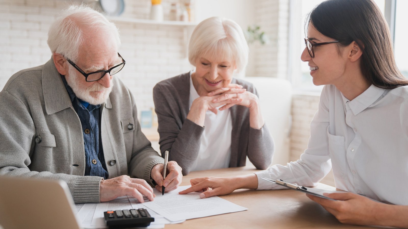 Retired couple reviewing documents at a table with their advisor